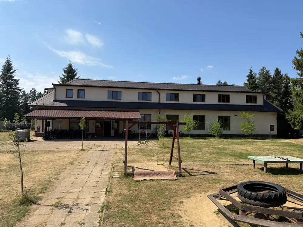 Hlavní budova RS Radost z boku, v popředí houpačky